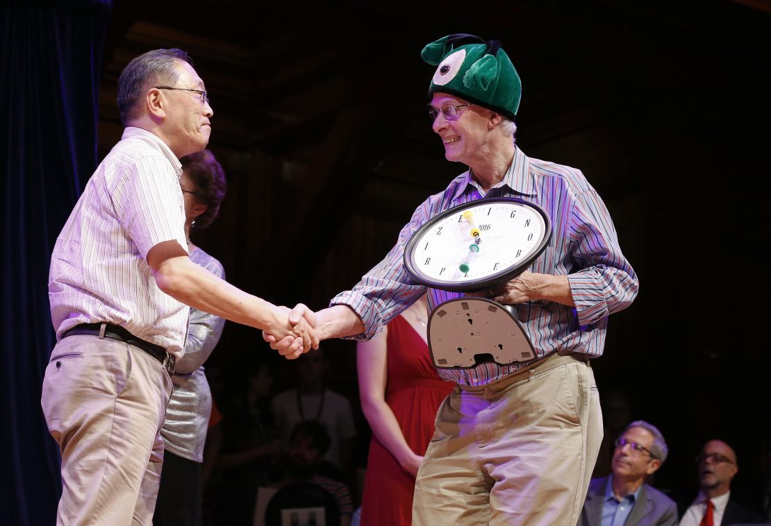 Atsuki Higashiyama, left, from Ritsumeikan University in Japan, accepts the Ig Nobel Perception prize for investigating whether things look different when you bend over and view them between your legs. 