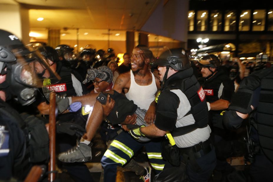 Police officers and protesters carry a man who was shot during the second night of protests on Wednesday, September 21. The shooting victim, 26-year-old Justin Carr, later died. Police <a href="http://www.cnn.com/2016/09/23/us/charlotte-protests/index.html" target="_blank">have charged another civilian</a> in connection with Carr's death.