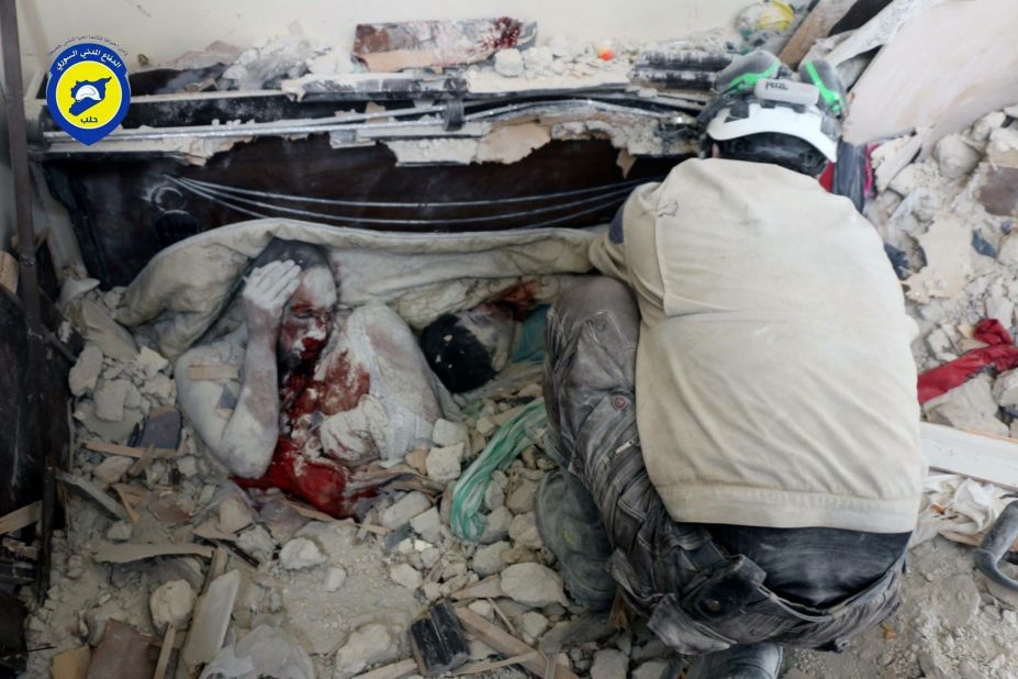 This photo was released by the volunteer group Syria Civil Defense of the bodies of a man, with his knee pulled up near his face, and a child covered in dust after they were killed in the airstrike. 