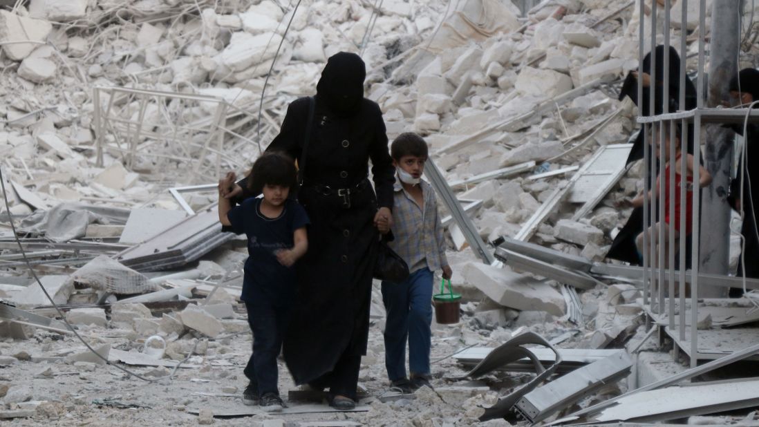 A Syrian family leaves the area following a reported airstrike on Friday, September 23, in rebel-held east Aleppo. Following the airstrike, recovery teams from Syria Civil Defense, known as the White Helmets, began working to free the trapped and recover the dead, including small children. 