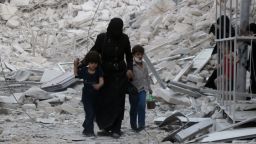 A Syrian family leaves the area following a reported airstrike on September 23, 2016, on the al-Muasalat area in the northern Syrian city of Aleppo.Missiles rained down on rebel-held areas of Syria's Aleppo, causing widespread destruction that overwhelmed rescue teams, as the army prepared a ground offensive to retake the city. / AFP / THAER MOHAMMED        (Photo credit should read THAER MOHAMMED/AFP/Getty Images)