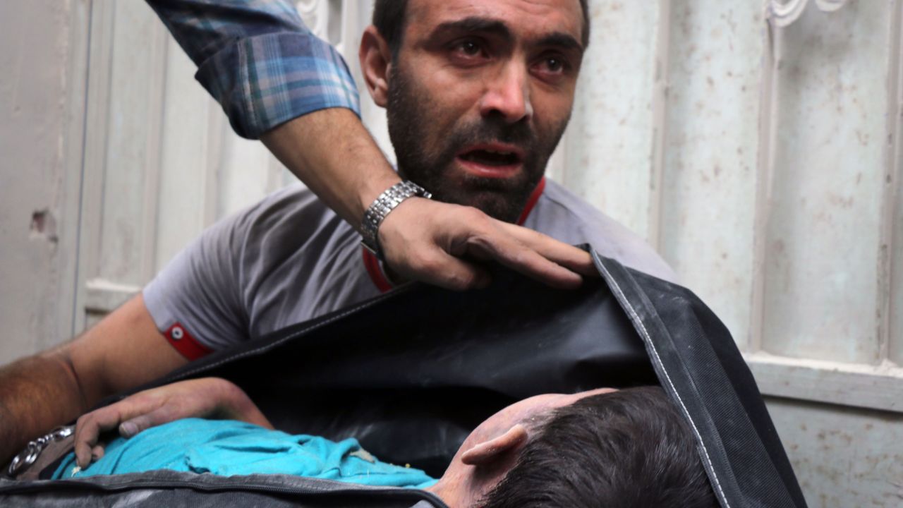 A Syrian man carries the body of his nephew, recovered from the rubble. 
