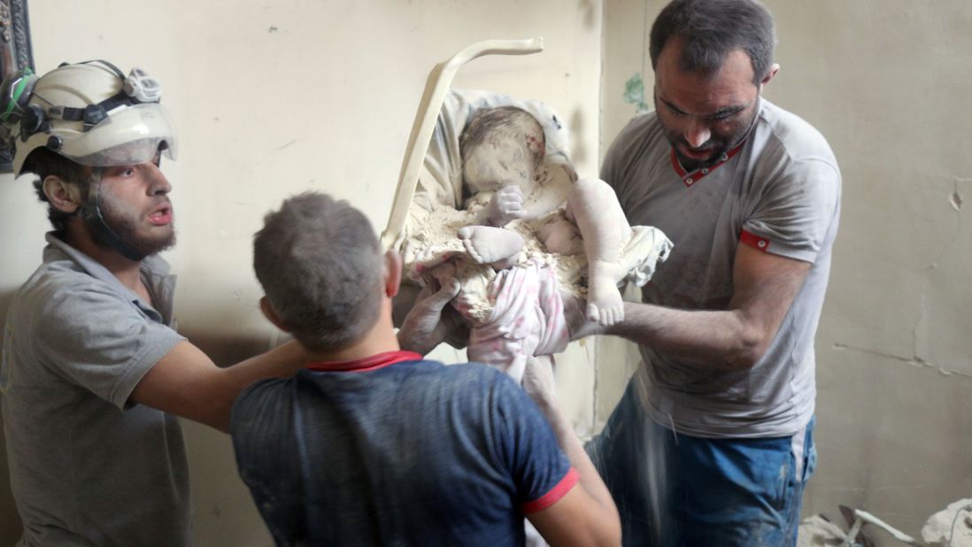 The volunteers remove an infant's body from the destroyed building. 