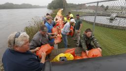 Volunteers and city workers place sandbags along the dike between the Cedar River and the water treatment plant in Cedar Falls, Iowa, Saturday, Sept.  24, 2016.   Authorities in several Iowa cities were mobilizing resources Friday to handle flooding from a rain-swollen river that has forced evacuations in several communities upstream, while a Wisconsin town was recovering from storms.  (Brandon Pollock/The Courier via AP)
