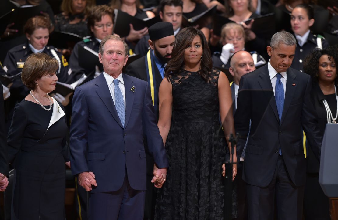 The Bushes and the Obamas join hands during the singing of "The Battle Hymn of the Republic" during an interfaith memorial service for the victims of the Dallas police shooting on July 12, 2016, in Dallas.
