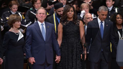 The Bushes and the Obamas join hands during the singing of "The Battle Hymn of the Republic" during an interfaith memorial service for the victims of the Dallas police shooting on July 12, 2016, in Dallas.
