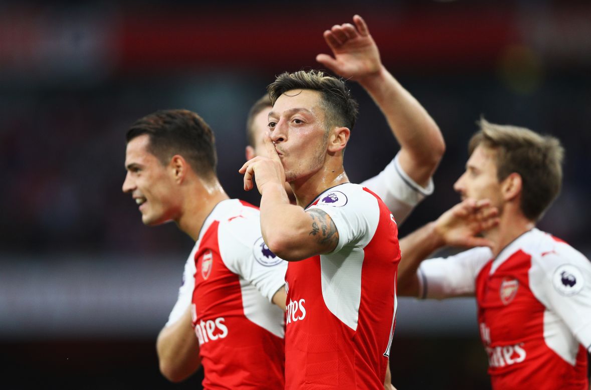 Mesut Ozil of Arsenal (C) celebrates scoring his side's third goal with teammates during the Premier League match between Arsenal and Chelsea at the Emirates Stadium. 