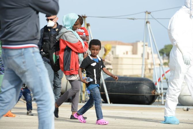 An excited young boy takes his first steps on land after several days at sea.