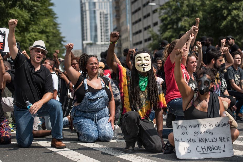 Demonstrators take a knee outside Bank of America Stadium as the national anthem is played on September 25.