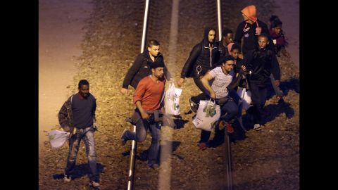 Migrants walk along the railway track leading to the Eurotunnel in Calais in August 2015. Migrants attempt to enter the UK illegally by stowing away on trucks, ferries, cars or trains.