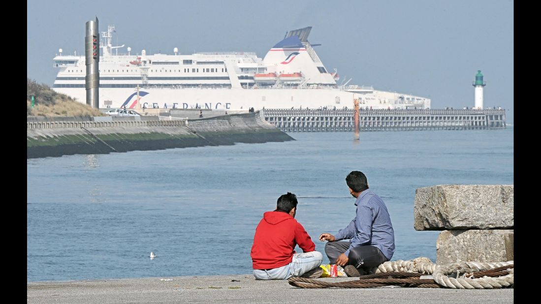 Migrants from Afghanistan look at a ferry boat in Calais in September 2009.