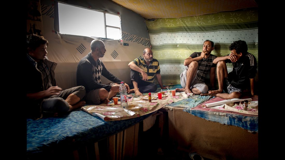 Afghan and Pakistani migrants eat lunch in the migrant camp in August 2015.