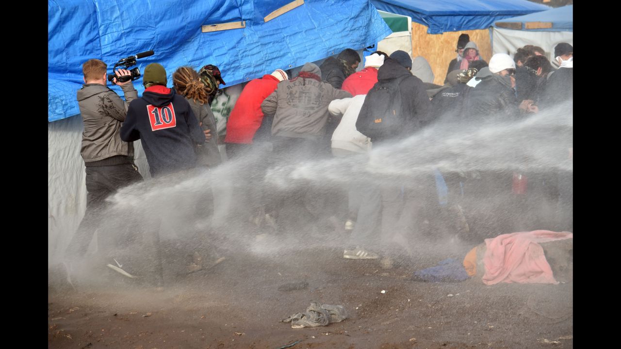 Riot police spray water on migrants to disperse them during the dismantling of half of "The Jungle" on February 29.
