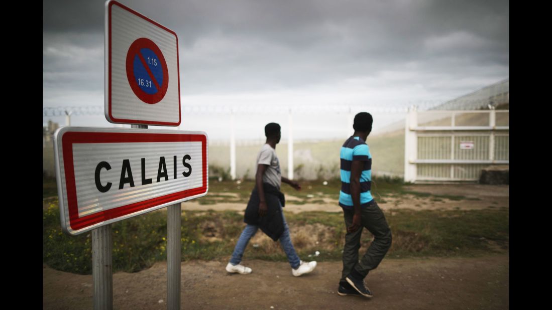 Migrants walk past security fencing on Tuesday, September 6.