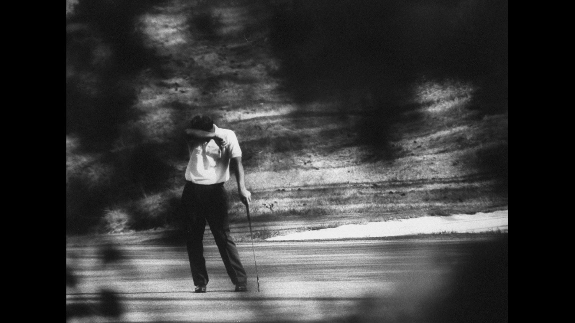 Here, he is seen through trees with club in hand during the 1960 Masters. Palmer would go on to win the tournament for the second time.