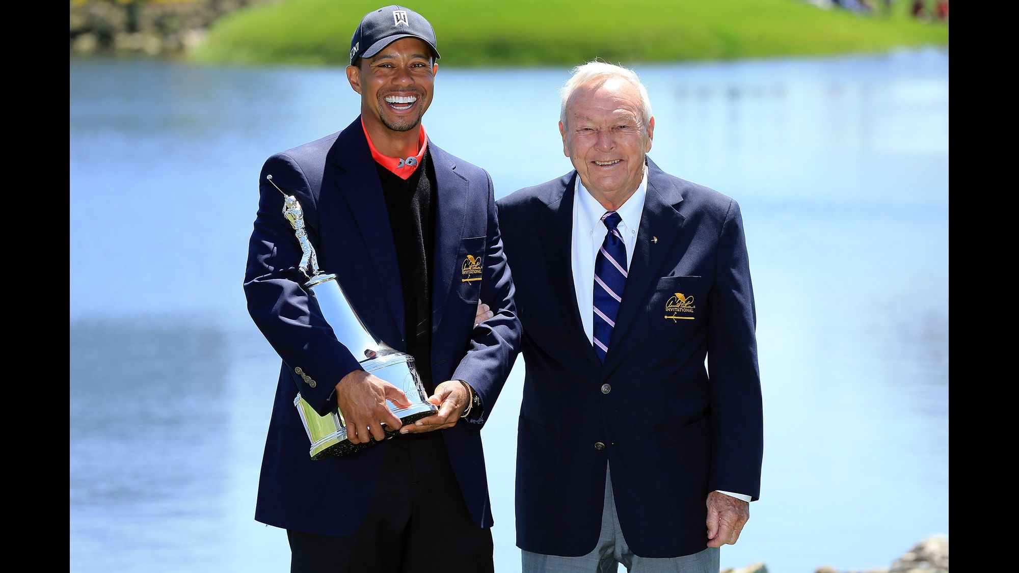 Tiger Woods is presented with a trophy by Palmer, after Woods won the final round of the 2013 Arnold Palmer Invitational Presented at Bay Hill Golf and Country Club.