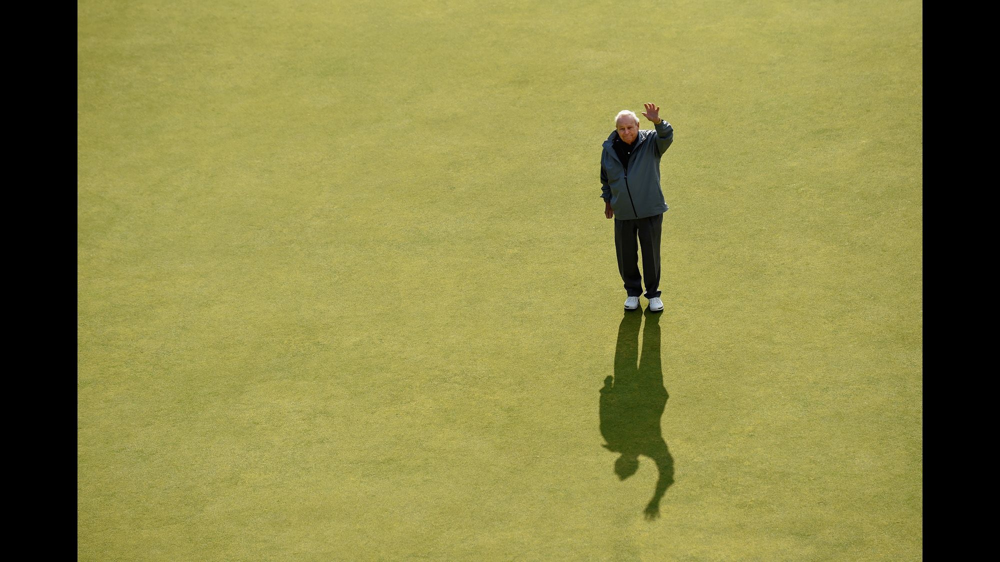 Palmer waves on the eighteenth green during the Champion Golfers' Challenge ahead of the 2015 British Open.