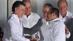 Cuban President Raul Castro greets Colombian President Juan Manuel Santos (L) and the leader of the FARC, Rodrigo Londono -- better known by his nom de guerre, Timoleon "Timochenko" Jimenez after the latter delivered a speech after signing the historic peace agreement between the Colombian government and the Revolutionary Armed Forces of Colombia (FARC), in Cartagena, Colombia, on September 26, 2016 
The Colombian government and the leftist FARC rebel force signed a historic peace accord to end a half-century conflict that has killed hundreds of thousands of people. Santos and "Timochenko" Jimenez, signed the deal at a ceremony in the Caribbean city of Cartagena, prompting loud cheers from the crowd which included numerous international dignitaries.
 / AFP / Luis ACOSTA        (Photo credit should read LUIS ACOSTA/AFP/Getty Images)