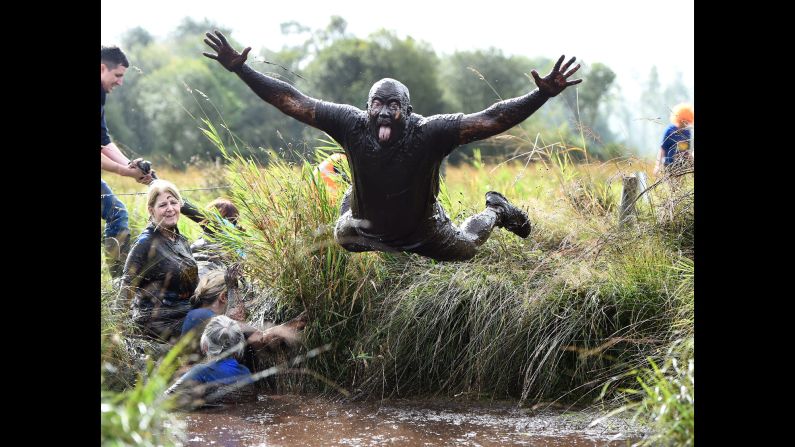 A man dives into the mud Sunday, September 25, during a charity "Mud Madness" race in Portadown, Northern Ireland.