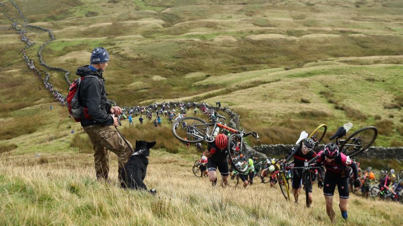 A man and his dog watch riders climb Simon Fell at the start of the Three Peaks Cyclo-Cross race in Helwith Bridge, England, on Sunday, September 25. <a href="http://www.cnn.com/2016/09/19/sport/gallery/what-a-shot-sports-0920/index.html" target="_blank">See 28 amazing sports photos from last week</a>