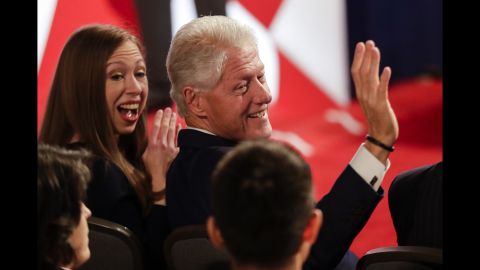 Bill Clinton, sitting next to daughter Chelsea, waves to the audience before the debate.
