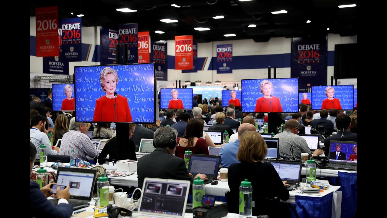 Clinton is seen on television monitors in the media center at Hofstra.