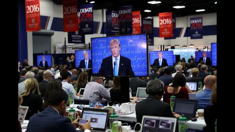 Trump appears on the media center screens.