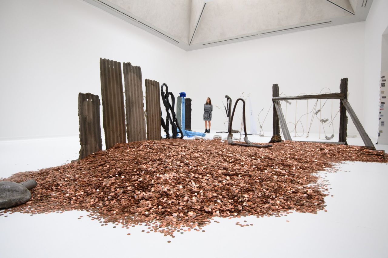 "Dean starts his process with writing, which he then gives physical form...using materials that are instantly recognisable from everyday life such as concrete, soil, sand, and corrugated sheet metal," says the museum. 