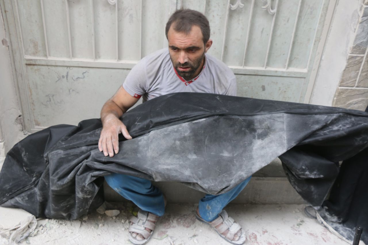 Mahmoud Sawas' uncle holds the boy's body after the deadly airstrike.