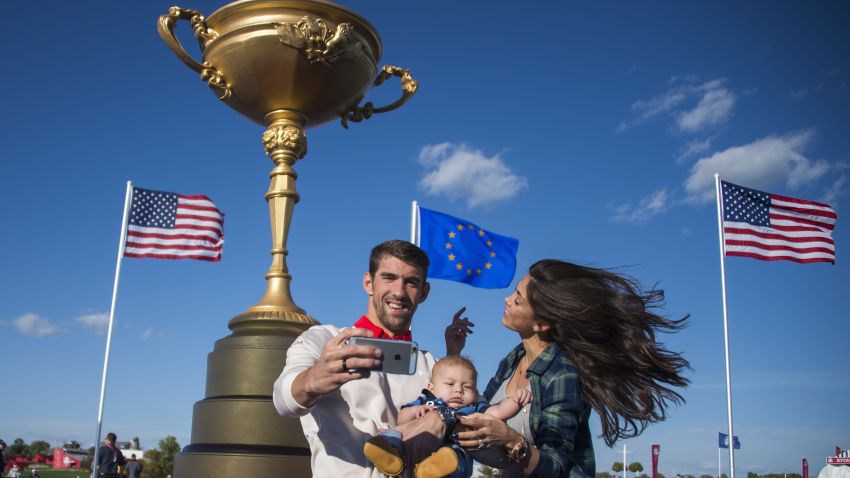 Olympic Gold Medalist Michael Phelps (L) and his fiancee Nicole Johnson (R) take a selfie with their son Boomer (C) at Hazeltine National Golf Course in Chaska, Minnesota on September 26, 2016, ahead of the 41st Ryder Cup.  / AFP / JIM WATSON        (Photo credit should read JIM WATSON/AFP/Getty Images)