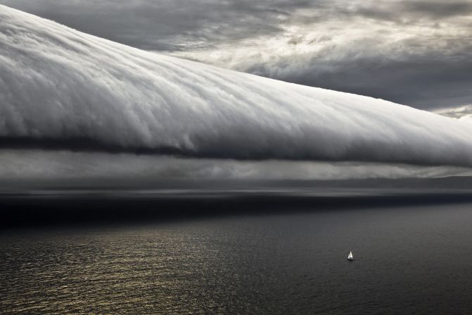 "The Rolex Sydney-Hobart Race, my favorite place to shoot.  And here is a good example of why, a very special weather event. The tiny boat is one of the last in the fleet from the 2010 edition of the race. And look at it, all alone out at sea with this giant cloud in its path.  Taken from the helicopter, away from the boat, this picture shows everything there is to know about being at sea in a race like this."