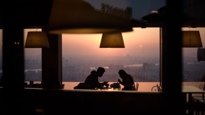 A couple eat in a restaurant overlooking the Seoul city skyline on February 13, 2015. Valentines day falls on February 14 when South Korean women usually give gifts to men, with the men reciprocating one month later on March 14. AFP PHOTO / Ed Jones        (Photo credit should read ED JONES/AFP/Getty Images)
