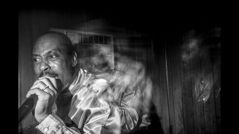 A long-exposure photograph of one of the church members singing.