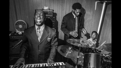 Pastor Roger Foster, the founder of the church, plays a keyboard while Willie helps his young son keep his timing on the drums.