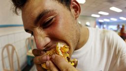 MIAMI BEACH, FL - JULY 18:  Jeff Baughman bites into his double cheeseburger with a Super Fries and a Super Coke on July 18, 2002 at a McDonalds in Miami Beach, Florida.  The health effects of an American diet of super-sized fast foods are becoming apparent as increasing numbers of children and adults are being treated for obesity.  Studies seem to point to the fact that many overweight children and adults get a large portion of their calories by consuming too many sodas and sweetened juices and beverages.  Sweetened drinks + "super-sized" meals + the convenience of fast food + a decrease in physical activity = a recipe for obesity.  (Photo by Joe Raedle/Getty Images)