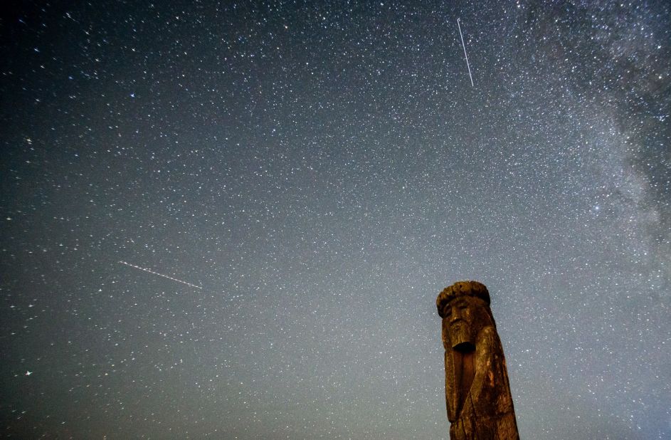 Shooting stars cross the night sky over a wooden idol near the village of Ptich some 25km away from Minsk, during the peak of the annual Perseid meteor shower on August 15, 2015. 