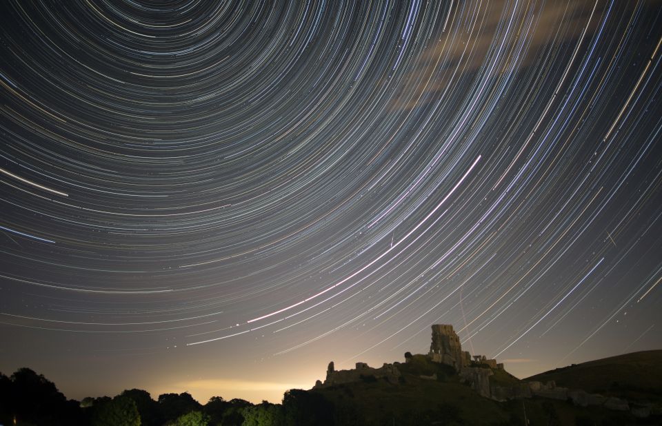 Satellites, planes and comets cross the night sky above Corfe Castle, in the United Kingdom, on August 12, 2016. 