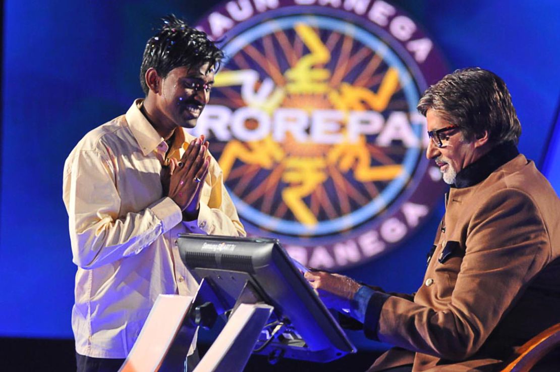 Sushil Kumar, 27, (L) gestures as he receives his one million USD prize from Bachchan during the fifth season of the Indian version of "Who Wants to be a Millionaire?" 