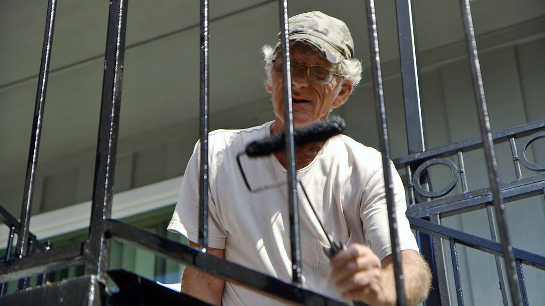 Turning Point Center resident Richard, 63, paints railings in the courtyard.