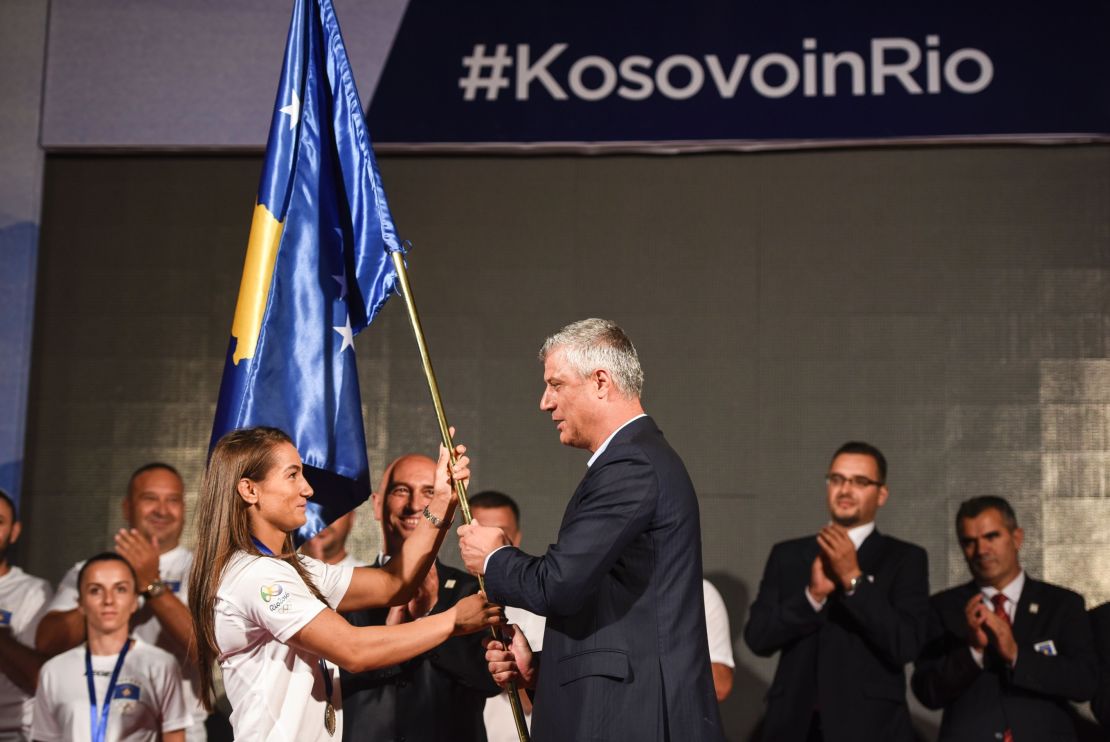 Kosovo's President Hashim Thaci  hands over the national flag to the Kosovar judoka Majlinda Kelmendi. 