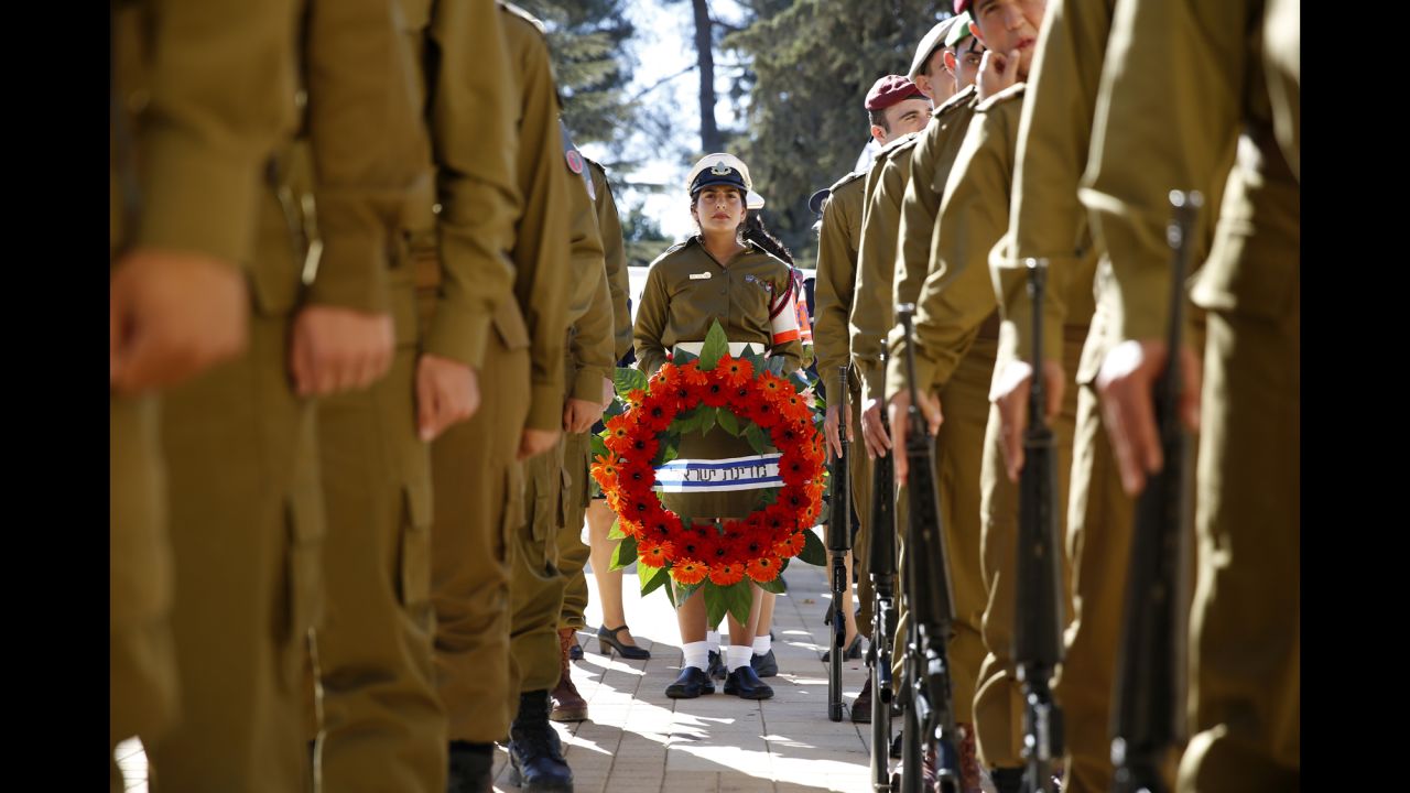 Israeli soldiers hold wreaths before making their way to the graveside.<br />