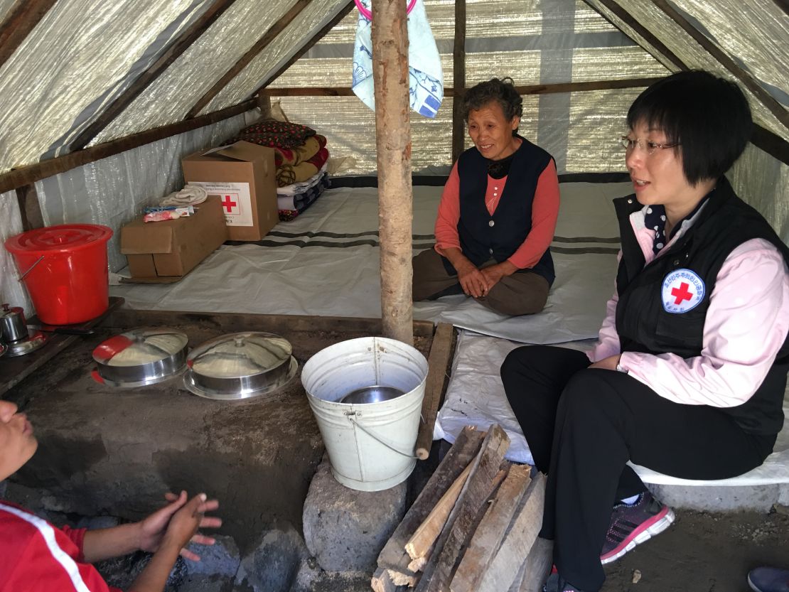 A Red Cross relief worker from the DPRK talks to flood survivors who received Red Cross relief supplies in Musan County.