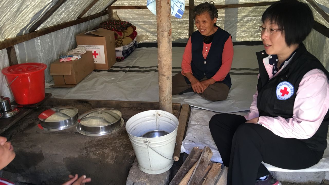 A Red Cross relief worker from the DPRK talks to flood survivors who received Red Cross relief supplies in Musan County.