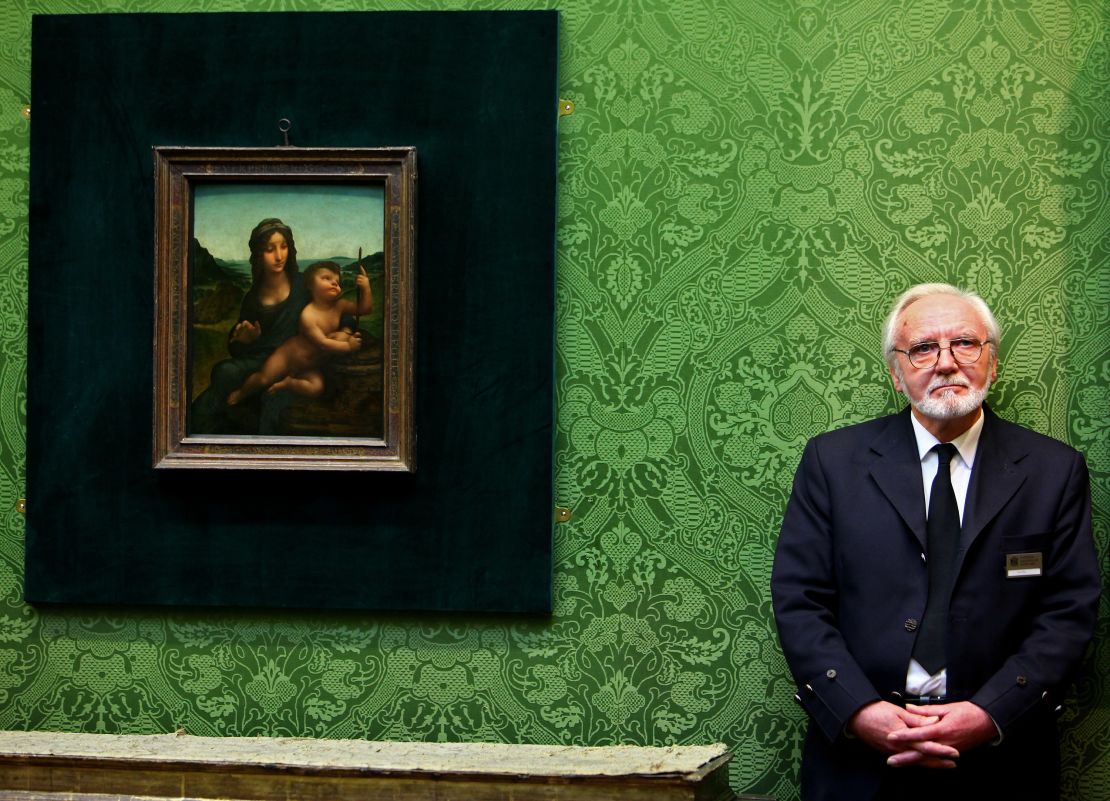 Joe Hay, security guard at the National Gallery of Scotland, stands beside the Leonardo da Vinci painting "Madonna of the Yarnwinder."