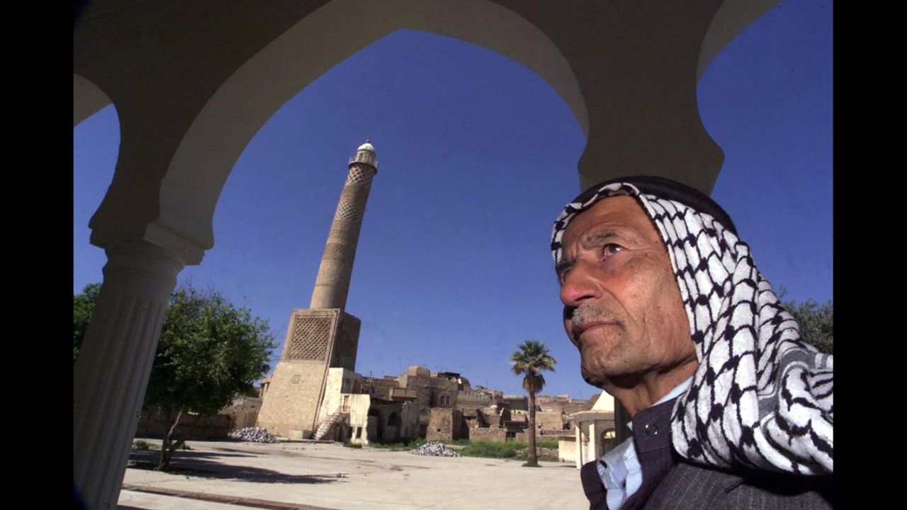 In this 2001 photo, a man stands before the Great Mosque's minaret, which leans like the Tower of Pisa and is nicknamed "al-Habda," or "the hunchback."