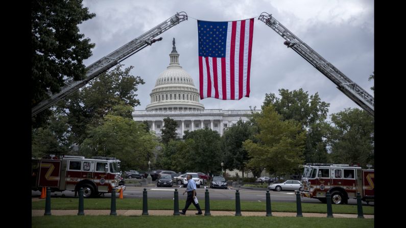 An American flag is suspended from the ladders of two fire trucks in Washington on Wednesday, September 28. Congress had just voted <a href="index.php?page=&url=http%3A%2F%2Fmoney.cnn.com%2F2016%2F09%2F28%2Fnews%2Foverride-obama-veto-911-bill%2F" target="_blank">to override a presidential veto</a> on legislation that would allow the families of 9/11 victims to sue the government of Saudi Arabia.