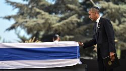 US President Barack Obama touches the flag-draped coffin of former Israeli president and prime minister Shimon Peres after speaking during his funeral at Jerusalem's Mount Herzl national cemetery on September 30, 2016.
World leaders bid farewell to Israeli elder statesman and Nobel Peace laureate Shimon Peres at his funeral in Jerusalem, with US President Barack Obama hailing him as a giant of the 20th century. / AFP / NICHOLAS KAMM        (Photo credit should read NICHOLAS KAMM/AFP/Getty Images)