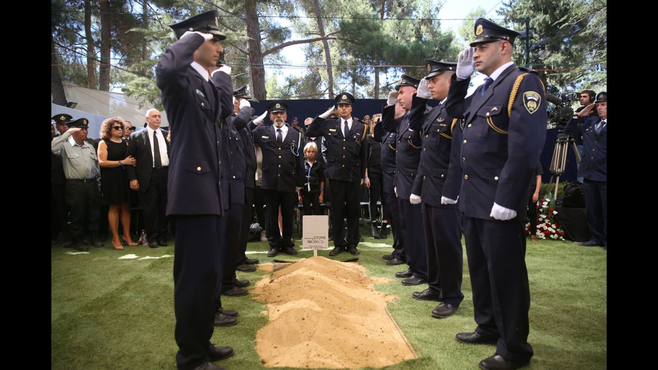 Members of the Knesset Guard salute around the grave.