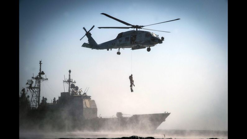 U.S. sailors are hoisted up by a helicopter during a search-and-rescue exercise in the Arabian Gulf on Friday, September 23.