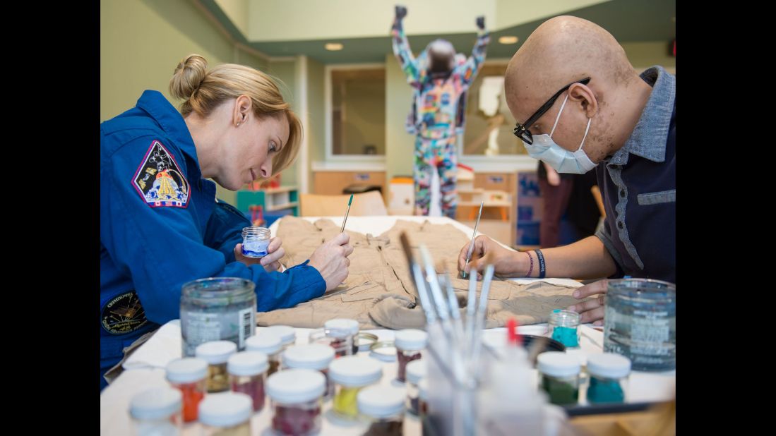 Rubins and pediatric cancer patient David Olazaba painted the first brush strokes on the Courage flight suit.